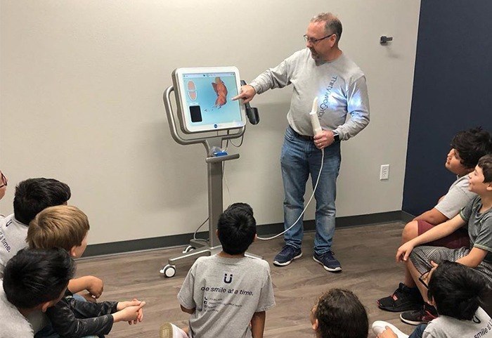 Dentist showing kids an image on the computer screen