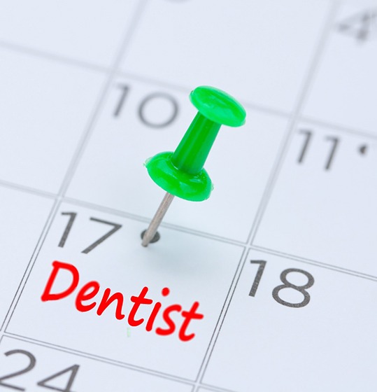 Dental appointment marked on calendar with green thumbtack
