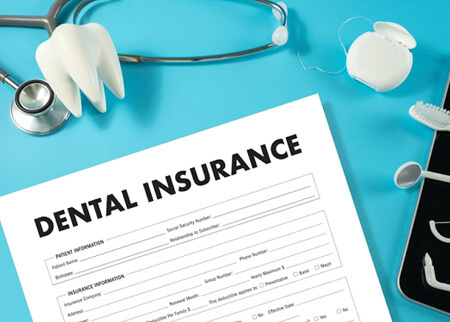 dental insurance document next tooth model and oral hygiene instruments