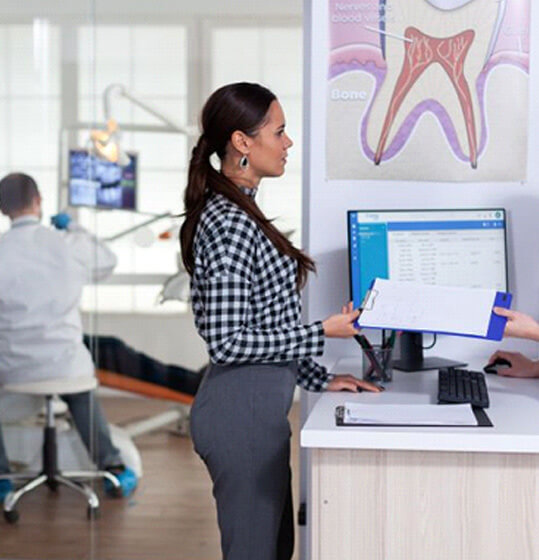 dental team member speaking with patient at front desk