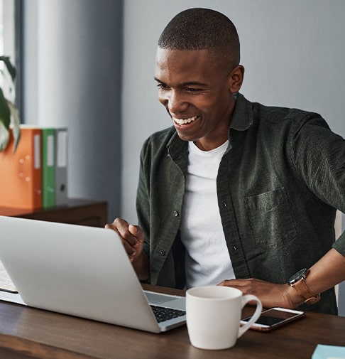 Man smiling while working on laptop at home