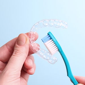 Patient cleaning clear aligner with toothbrush