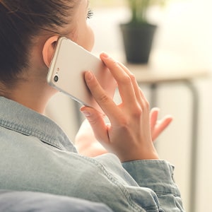 Woman smiling while talking on cell phone at home